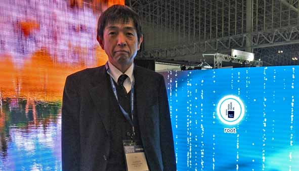 President Yabuta of CreateLED Japan. In the background is the high-definition 2.2 millimeter dot pitch LED